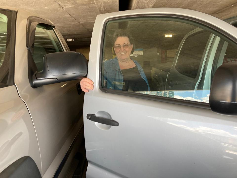 Diana Gordon demonstrates the challenge of opening her truck's door, even while parked in an accessible spot in the Harrah's Cherokee Center parking garage in July 2023.