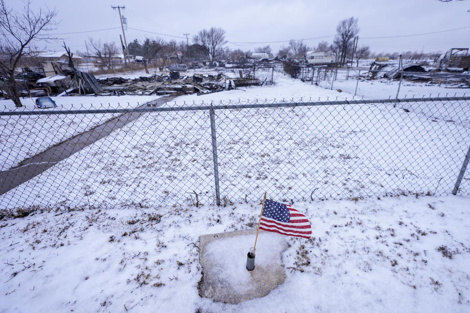 A U.S. flag waves in the wind in front of a home destroyed by the Smokehouse Creek Fire, Thursday, Feb. 29, 2024, in Stinnett, Texas. (AP Photo/Julio Cortez)