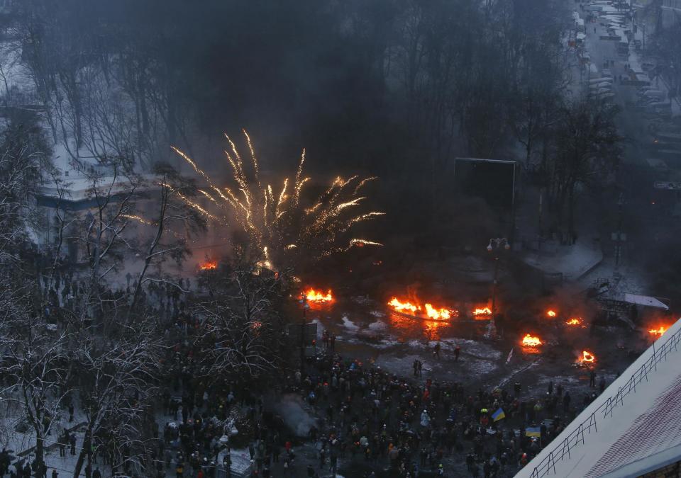 Tires burn in the street, set alight by protesters in clashes with police in central Kiev, Ukraine, Wednesday, Jan. 22, 2014. Police in Ukraine’s capital on Wednesday tore down protester barricades and chased demonstrators away from the site of violent clashes, hours after two protesters died after being shot, the first violent deaths in protests that are likely to drastically escalate the political crisis that has gripped Ukraine since late November. (AP Photo/Sergei Grits)