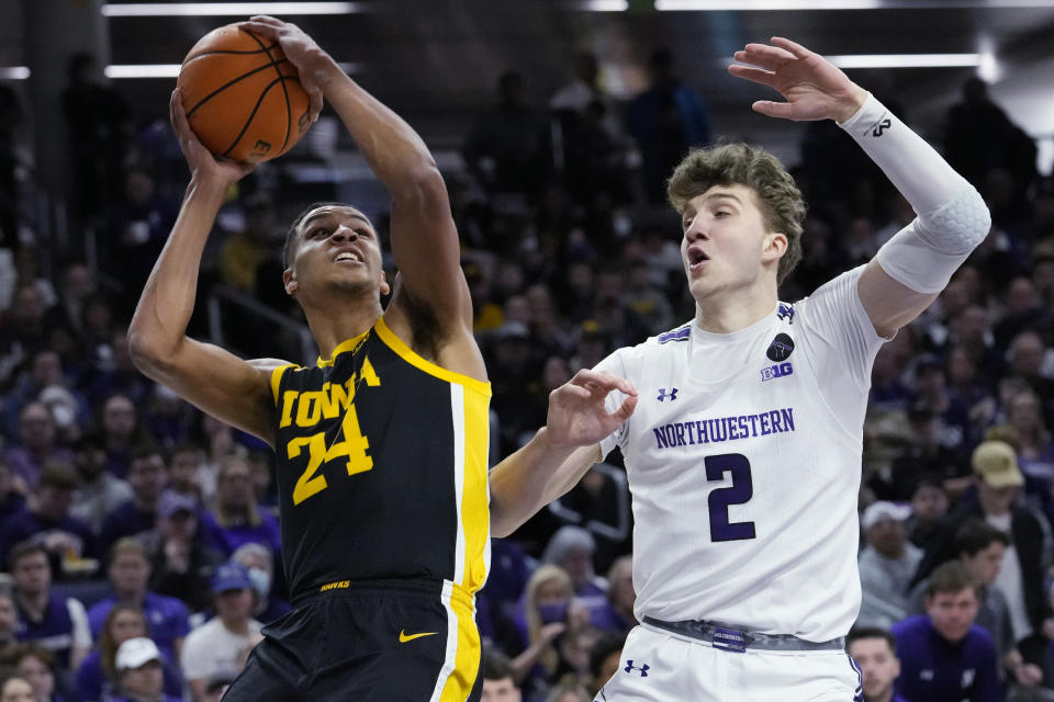 Iowa forward Kris Murray, left, drives to the basket as Northwestern forward Nick Martinelli defends during the first half of an NCAA college basketball game in Evanston, Ill., Sunday, Feb. 19, 2023. (AP Photo/Nam Y. Huh)