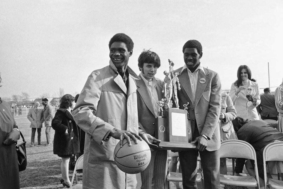 Dolton Thornridge tri-captains Boyd Batts, Mike Bonczyk and Quinn Buckner hold the class AA Illinois State High School basketball tourney championship trophy and game ball after their return to Dolton on Sunday, March 20, 1972 in Illinois. The Falcons won their 54th straight game to take the title, their second in a row. Thornridge beat Quincy Saturday in Championship, 104-69, for the crown. (AP Photo/ESK)