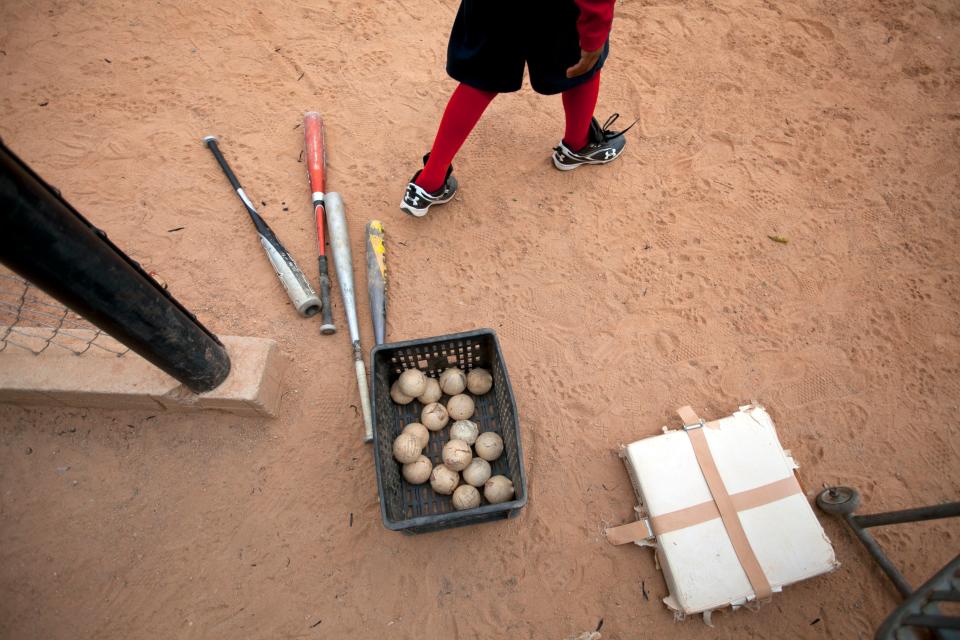 A boy walks near bats and baseballs during practice at the field where Detroit Tigers' Miguel Cabrera learned to play, in Maracay, Venezuela, Friday, March 28, 2014. Residents of this hardscrabble neighborhood say the grounded superstar is a model for local youth, who must navigate a more treacherous path than he did. They remember Cabrera as a single-minded child who only put down the bat to study, and stayed home most nights. (AP Photo/Alejandro Cegarra)