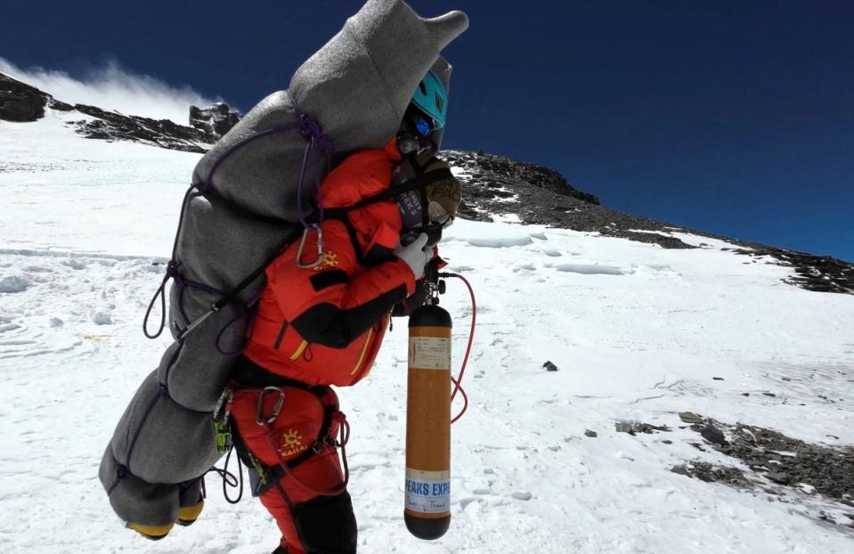 Ngima Tashi Sherpa walks as he carries a Malaysian climber while rescuing him from the death zone above camp four at Everest, Nepal, 18 May  2023 in this screengrab obtained from a handout video (Gelje Sherpa via Reuters)