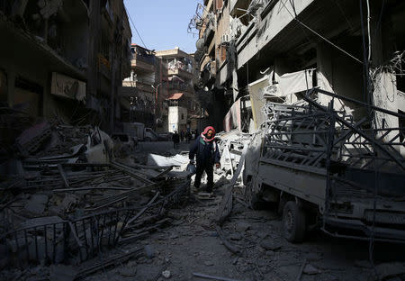 A man walks on the rubble of damaged buildings at the besieged town of Douma, Eastern Ghouta, Damascus, Syria. REUTERS/Bassam Khabieh