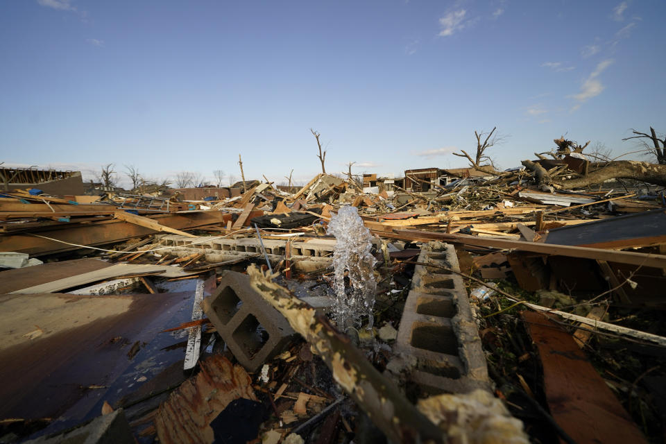 A water pipe spews water amidst rubble from destroyed homes in the aftermath of tornadoes that tore through the region, in Mayfield, Ky., Tuesday, Dec. 14, 2021. (AP Photo/Gerald Herbert)