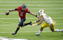 UNLV quarterback Max Gilliam (6) scrambles under pressure from Wyoming linebacker Charles Hicks (33) during the first half of an NCAA college football game in Las Vegas on Friday, Nov. 27, 2020. (Steve Marcus/Las Vegas Sun via AP)