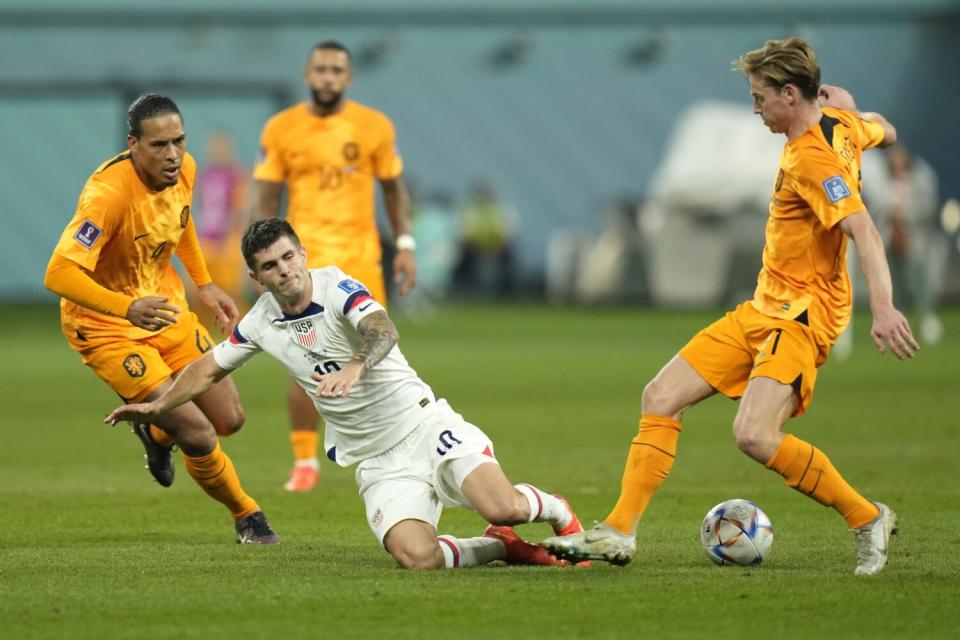 U.S. forward Christian Pulisic, center, and Frenkie de Jong of the Netherlands battle for the ball.