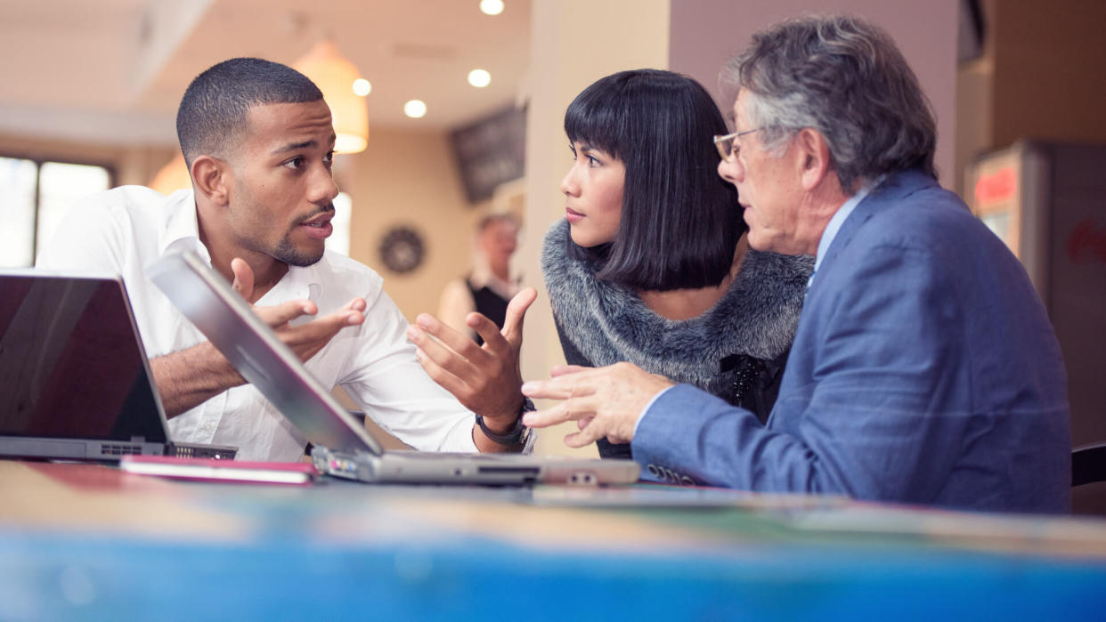 Three people talking business in a relaxed bar environment.