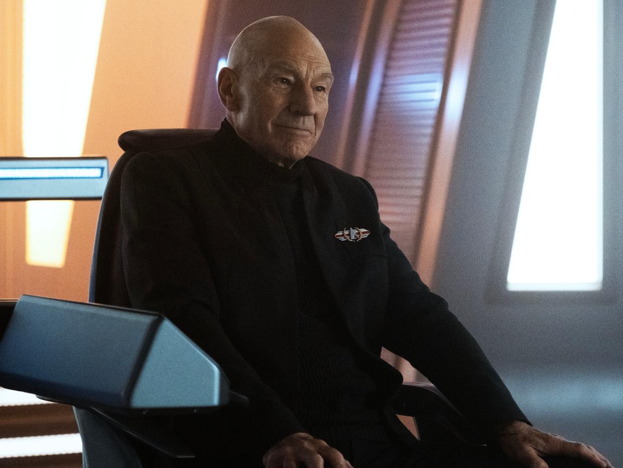 Patrick Stewart as Jean-Luc Picard sitting in a chair in a high-tech room in an episode of "Star Trek: Picard".