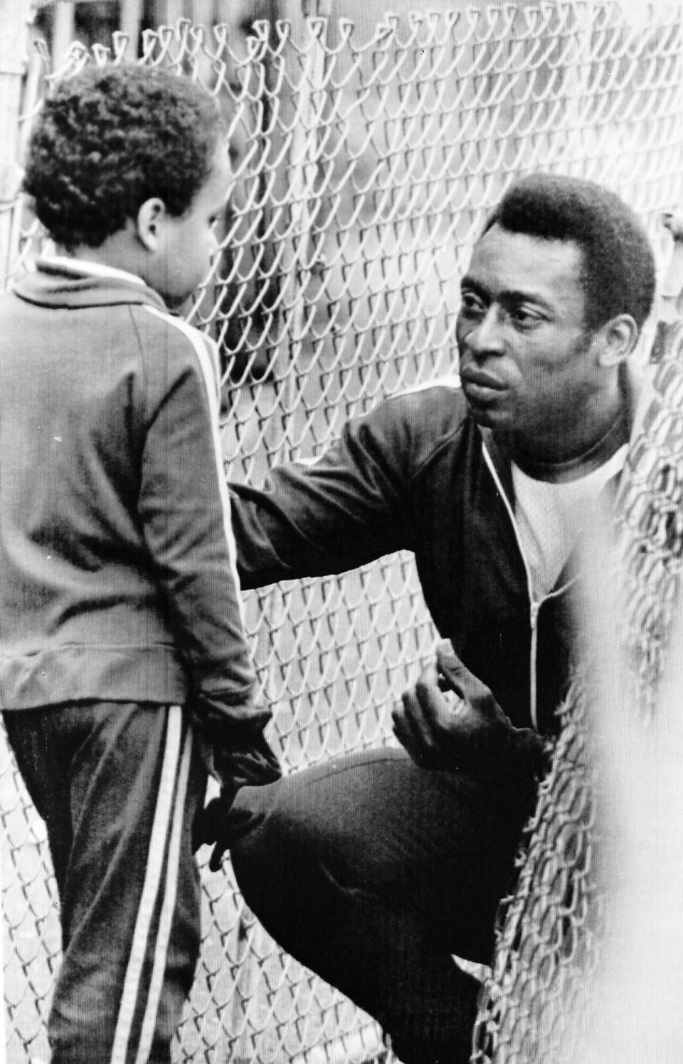 Brazil's soccer star Pele, talks with his 7-year-old son Edson, during a break in training, as the New York Cosmos worked out in a field in Portland,, in preperation for the match against Seattle PELE WITH SON EDSON 1977, PORTLAND, USA