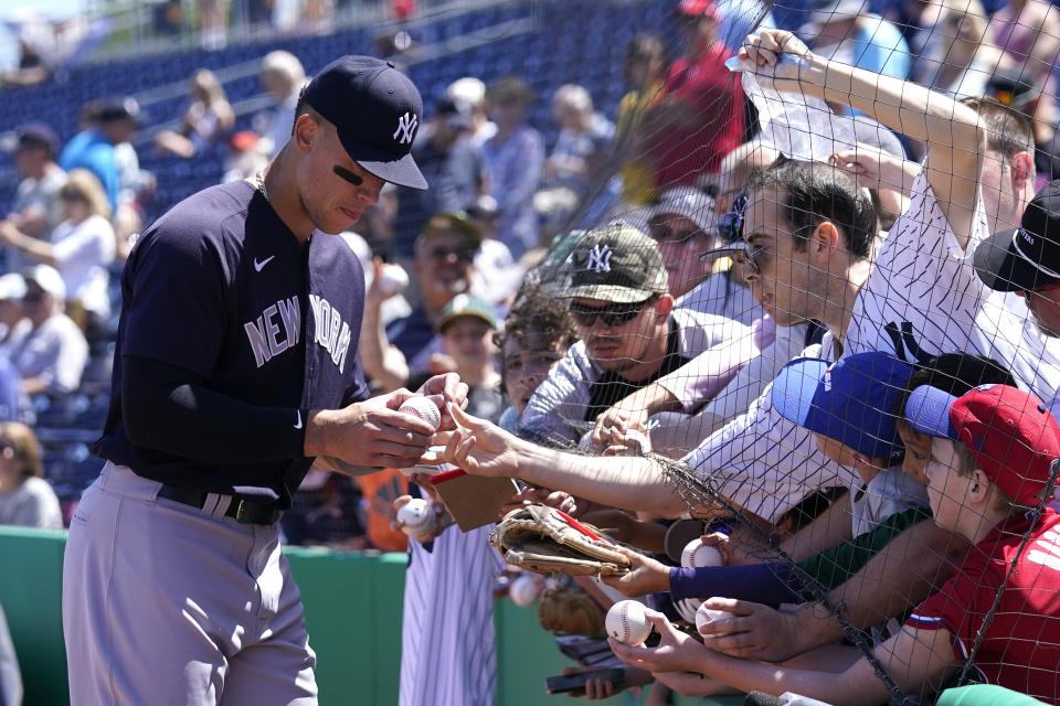 New York Yankees' Aaron Judge signs autographs for fans before a spring training baseball game against the Philadelphia Phillies, Friday, March 25, 2022, in Clearwater, Fla. (AP Photo/Lynne Sladky)