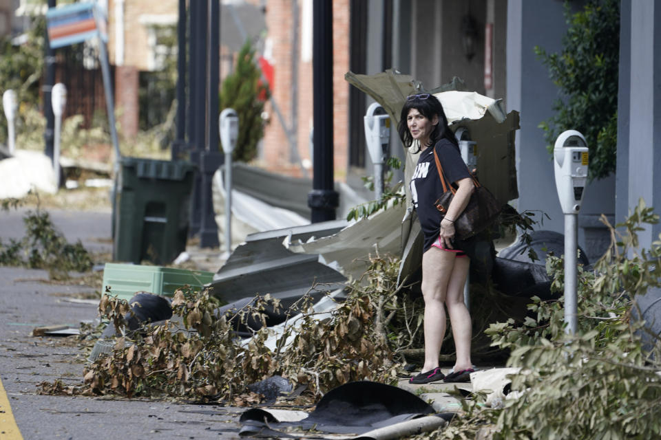 A pedestrian tries to cross a debris filled street in downtown as residents and try to recover from the effects of Hurricane Ida Tuesday, Aug. 31, 2021, in Houma, La. (AP Photo/Steve Helber)