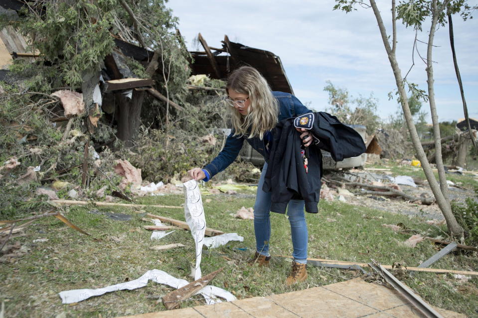 <p>Laurel Wingrove picks up stickers and a firefighter’s jacket belonging to her boyfriend that were thrown outside their home when it was damaged by a tornado in Dunrobin, Ont., west of Ottawa, on Sunday, Sept. 23, 2018. The storm tore roofs off of homes, overturned cars and felled power lines in the Ottawa community of Dunrobin and in Gatineau, Que. (Photo from Justin Tang/The Canadian Press) </p>