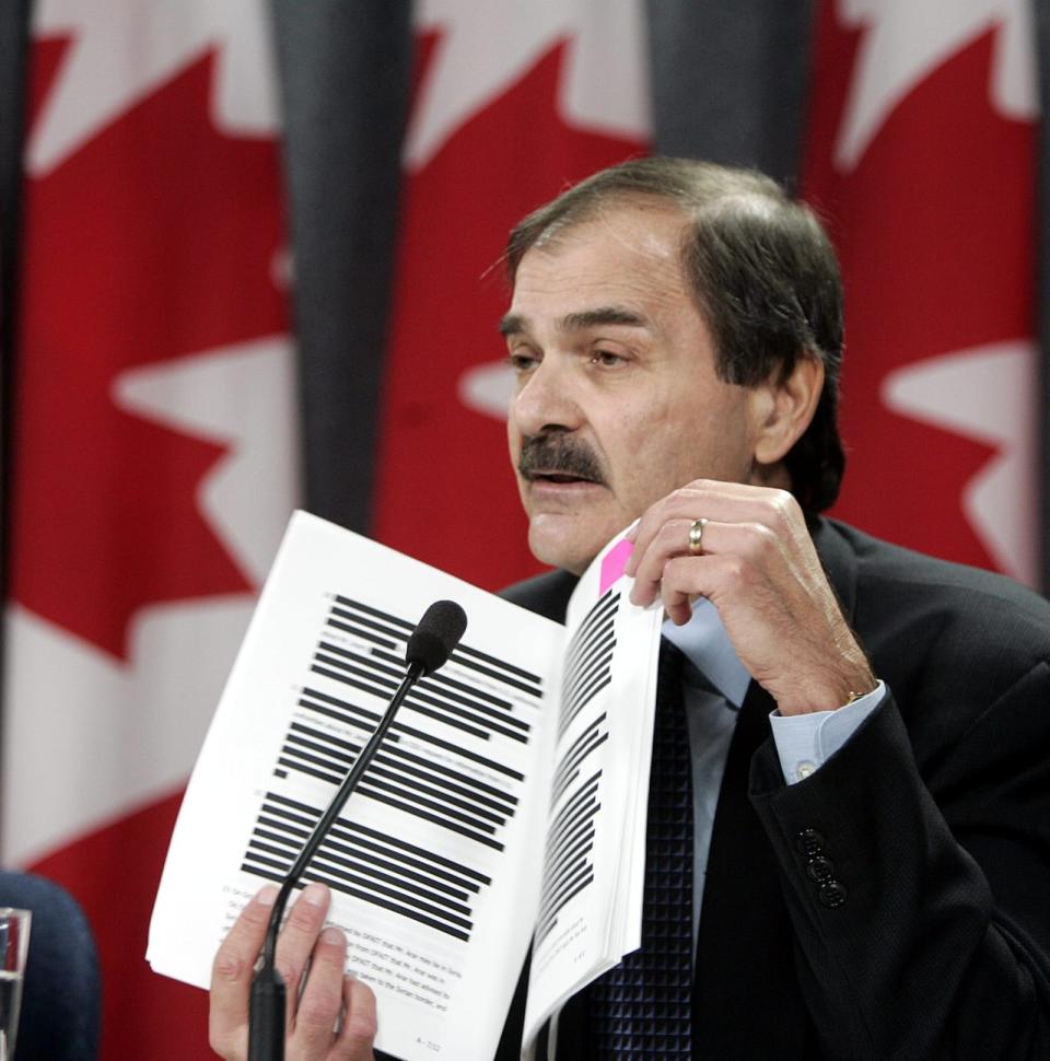 Paul Cavalluzzo, lead commission council for the Arar inquiry, holds up a copy of documents that have been blacked-out for security reasons at a news conference in Ottawa Monday Dec. 20, 2004. The Canadian Security Intelligence Service clashed with the Foreign Affairs Department over a proposed letter intended to free Arar from the Syrian prison, information disclosed Monday by the federal inquiry into the Ottawa man’s case shows.