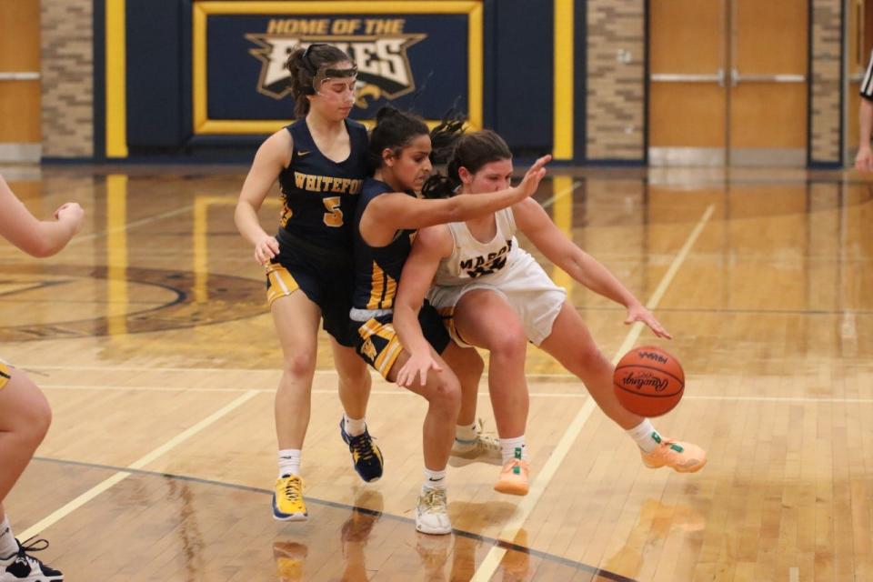 Erie Mason’s Lizzie Liedel collides with Whiteford defenders Anna VanBrandt (5) and Patrina Marsh Friday night. Mason won 50-42.