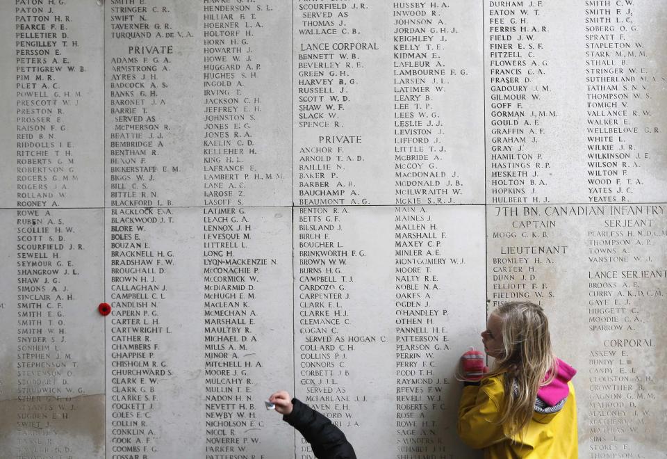 A girl looks at engraved names of Commonwealth soldiers who died in World War One, at the Menin Gate Memorial in Ypres