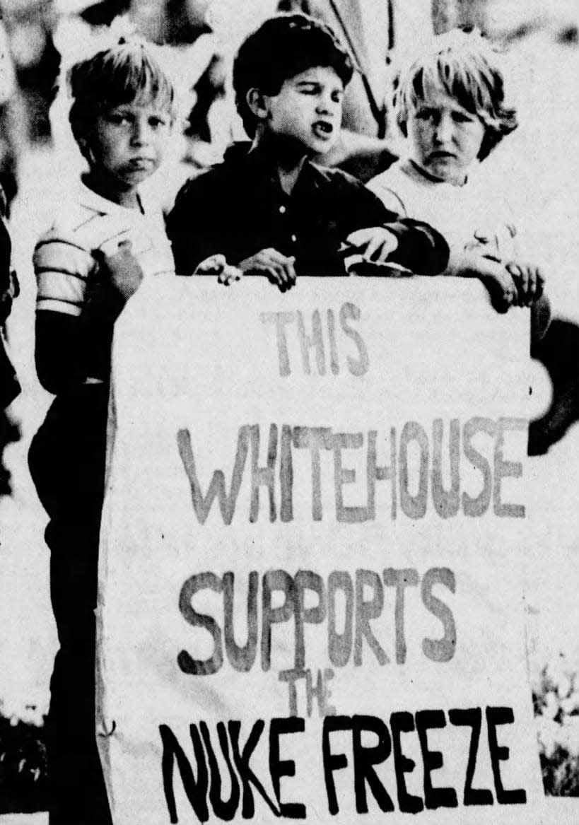 Young protesters, from left, Davey Harood, Terry Stokes and Sonia Pascadlo, all of Readington, send a message to Reagan.