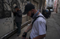 Two drug addicts smoke fentanyl in an alley in Los Angeles, Monday, April 18, 2022. Because it's 50 times more potent than heroin, even a small dose can be fatal. It has quickly become the deadliest drug in the nation, according to the Drug Enforcement Administration. Two-thirds of the 107,000 overdose deaths in 2021 were attributed to synthetic opioids like fentanyl, the U.S. Centers for Disease Control and Prevention says. (AP Photo/Jae C. Hong)