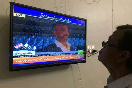 A man looks at television screen, airing live transmission of released Indian pilot Wing Commander Abhinandan, at Wagah border, in Karachi, Pakistan March 1, 2019. REUTERS/Akhtar Soomro