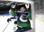 Vancouver Canucks left wing Tanner Pearson, right, goes into the boards with Winnipeg Jets defenseman Dylan DeMelo (2) during second-period NHL hockey game action in Vancouver, British Columbia, Sunday, Feb. 21, 2021. (Jonathan Hayward/The Canadian Press via AP)