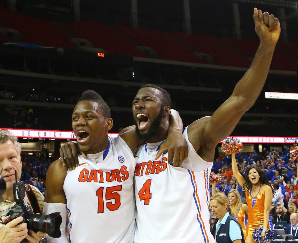 Florida forward Will Yeguete, left, and center Patric Young celebrate after beating Kentucky in an NCAA college basketball game in the championship for the Southeastern Conference tournament, Sunday, March 16, 2014, in Atlanta. Florida won 61-60. (AP Photo/Atlanta Journal-Constitution, Curtis Compton)