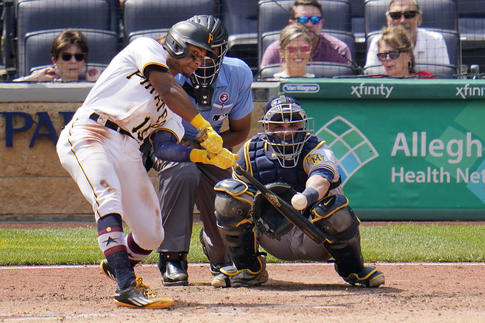 Pittsburgh Pirates Wilmer Difo, left, doubles off Milwaukee Brewers relief pitcher Freddy Peralta, driving in a run, during the sixth inning of a baseball game in Pittsburgh, Sunday, July 4, 2021 Brewers catcher Manny Pina, right, looks on. (AP Photo/Gene J. Puskar)