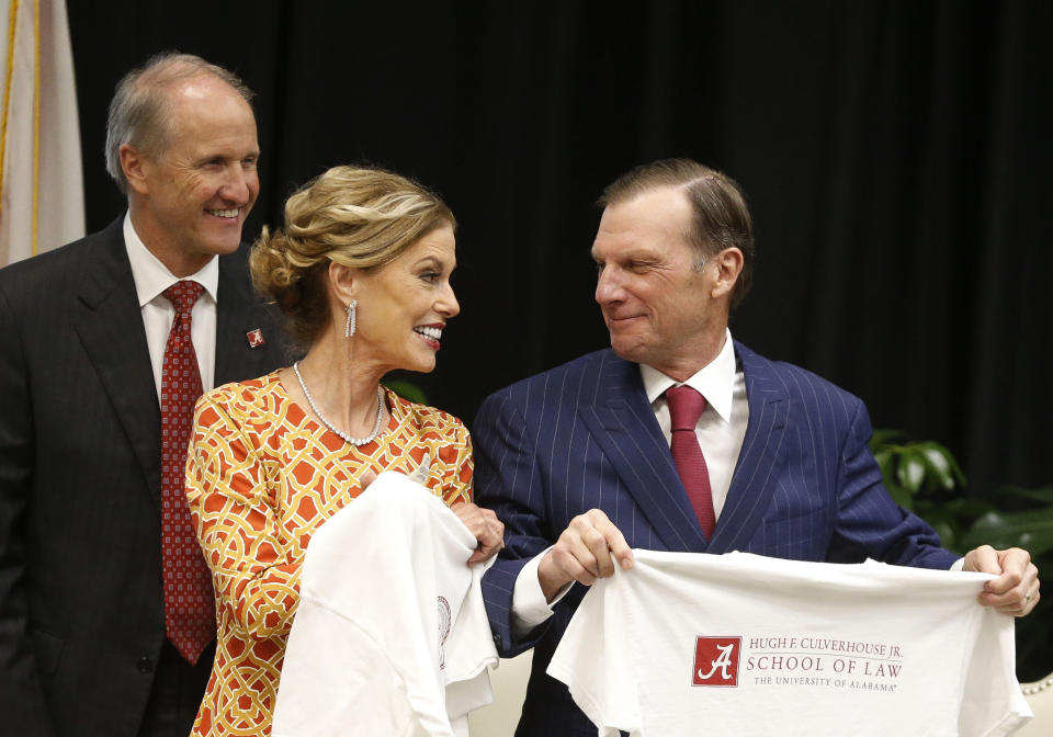 In this Sept. 20, 2018, photo, Hugh F. Culverhouse Jr., right, and wife, Eliza, in Tuscaloosa, Ala., show off T-shirts from the the University of Alabama law school, which now bears his name. The university appears poised to reject a $26.5 million pledge by Culverhouse, who recently called on students to boycott the university over the state’s new abortion ban. (Gary Cosby Jr./The Tuscaloosa News via AP)