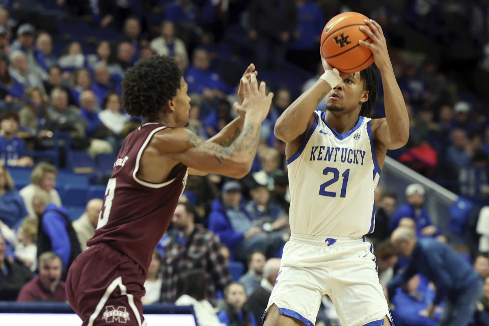 Kentucky's D.J. Wagner (21) shoots while defended by Mississippi State's Shakeel Moore, left, during the second half of an NCAA college basketball game, Wednesday, Jan. 17, 2024, in Lexington, Ky. Kentucky won 90-77. (AP Photo/James Crisp)