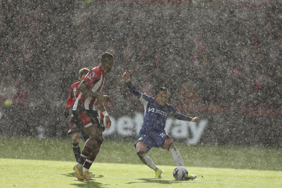 Chelsea's Malo Gusto, right, plays the ball during heavy rain at an English Premier League soccer match between Brentford and Chelsea at the Gtech Community Stadium in London , Saturday, March 2, 2024. (AP Photo/Ian Walton)