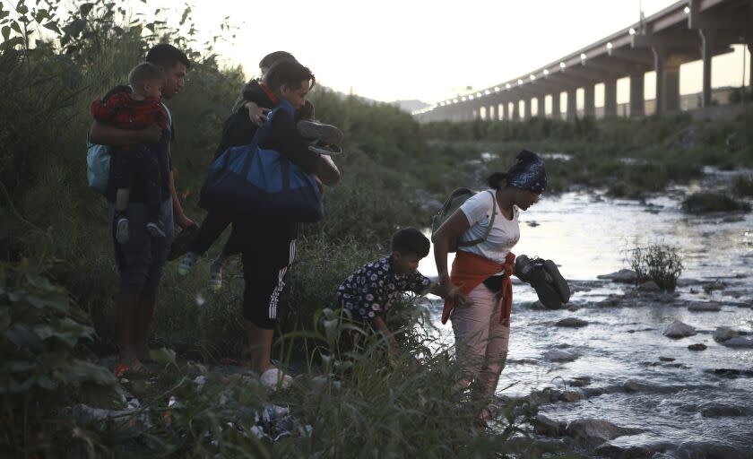 Venezuelan migrants walk across the Rio Bravo towards the United States border to surrender to the border patrol, from Ciudad Juarez, Mexico, Thursday, Oct. 13, 2022. The U.S. announced on Oct. 12, that Venezuelans who walk or swim across the border will be immediately returned to Mexico without rights to seek asylum. (AP Photo/Christian Chavez)