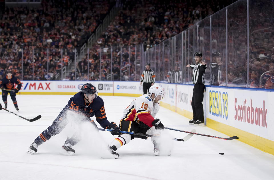 Edmonton Oilers' Ryan Nugent-Hopkins (93) and Calgary Flames' Derek Ryan (10) vie for the puck during the first period of an NHL hockey game Friday, Dec. 27, 2019, in Edmonton, Alberta. (Darryl Dyck/The Canadian Press via AP)