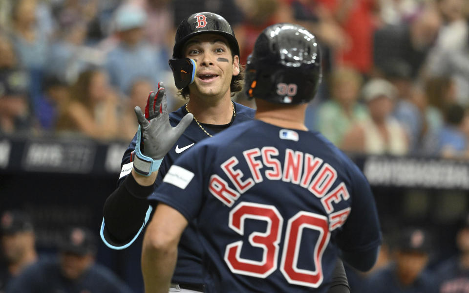 Boston Red Sox's Triston Casas, left, congratulates Rob Refsnyder (30) after Refsnyder's solo home run off Tampa Bay Rays starting pitcher Jeffrey Springs during the first inning of a baseball game Thursday, April 13, 2023, in St. Petersburg, Fla. (AP Photo/Steve Nesius)