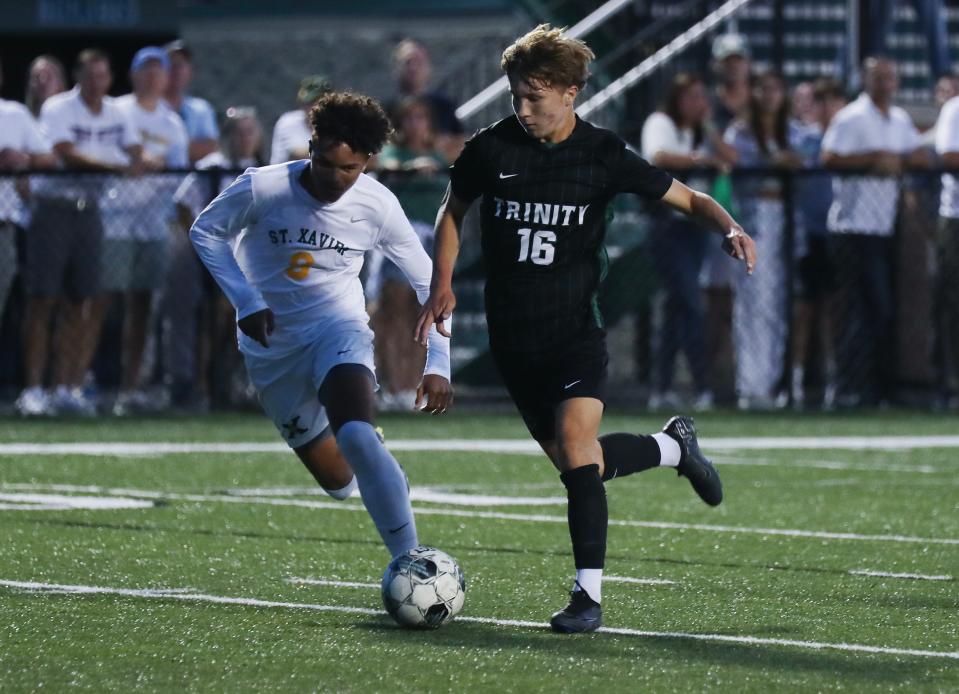Trinity's Grayson Travis (16) dribbles against against St. X's Gavin Yearwood (8) during their match at the St. X High School  in Louisville, Ky. on Sep. 20, 2023.
