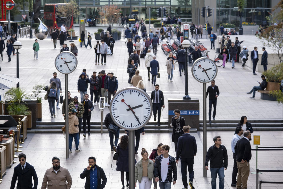 City workers walk under the clocks of Nash Court in Reuters Plaza at the base of One Canada Square, at the heart of Canary Wharf financial district on 14th October 2022 in London, United Kingdom. Canary Wharf is an area located near the Isle of Dogs in the London Borough of Tower Hamlets and is defined by the Greater London Authority as being part of London's central business district. Along with the City of London, it constitutes one of the main financial centres in the United Kingdom and the world, containing many high-rise buildings including the third-tallest in the UK, One Canada Square. (photo by Mike Kemp/In Pictures via Getty Images)