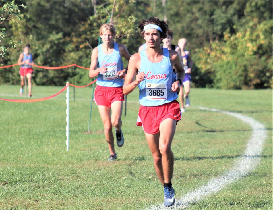 Conner seniors Ryan Hanak, left, and Joseph Impellitterri lead the way in the boys race during the boys varsity race of the Northern Kentucky Athletic Conference cross country meet Oct. 9, 2021, at Idlewild Park, Burlington, Ky.