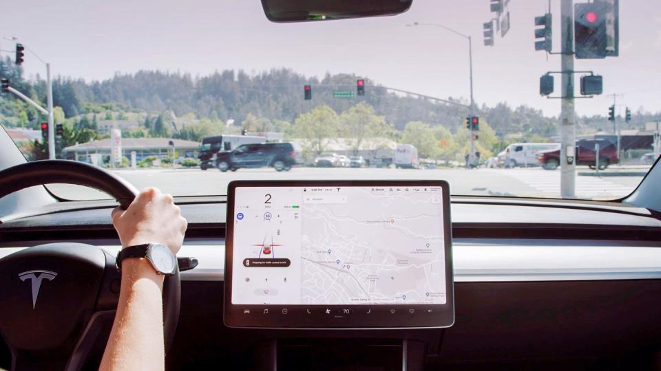 a person holding a steering wheel in a tesla car