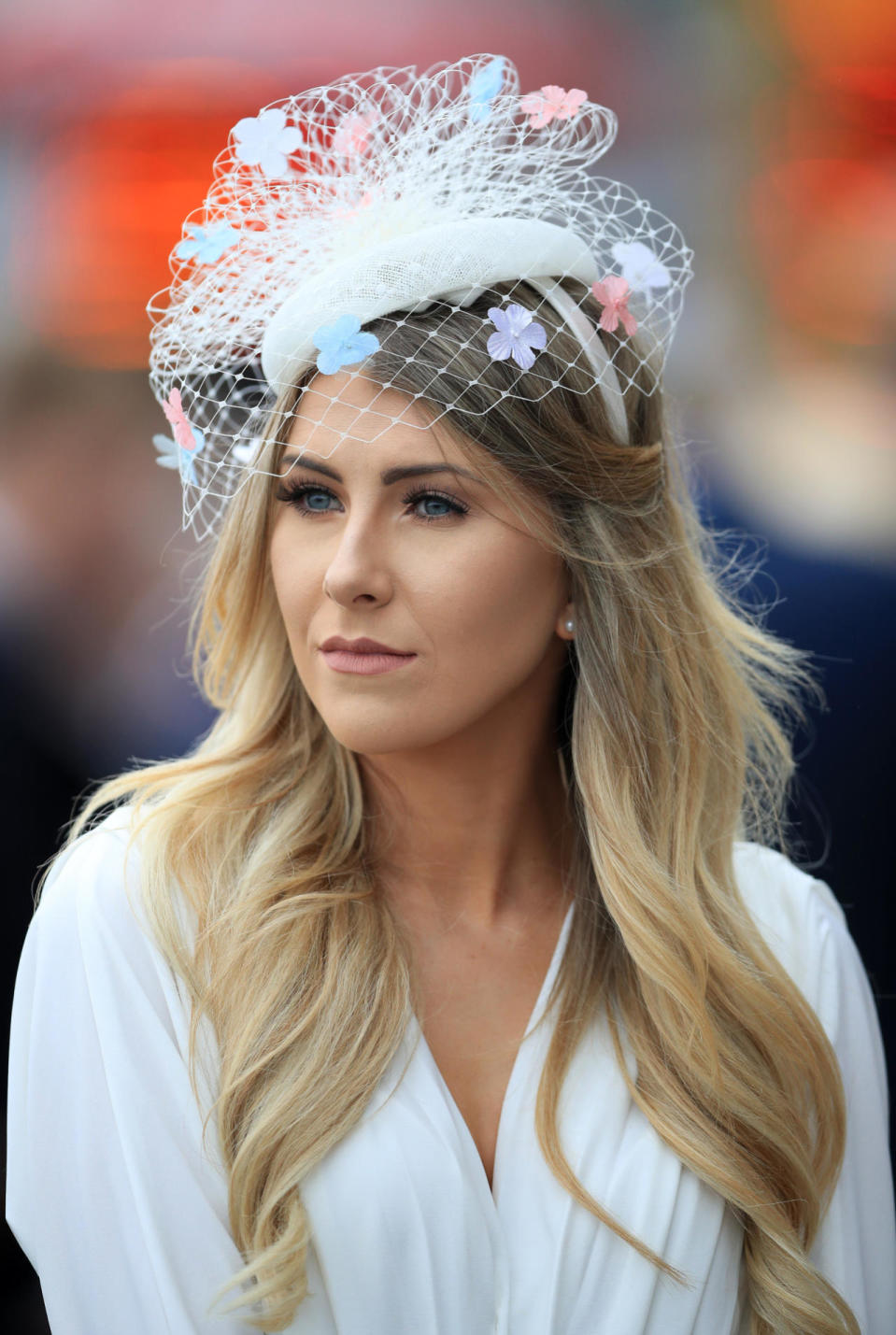 This delicate hat, adorned with pastel flowers, was paired with a simple white ensemble. 