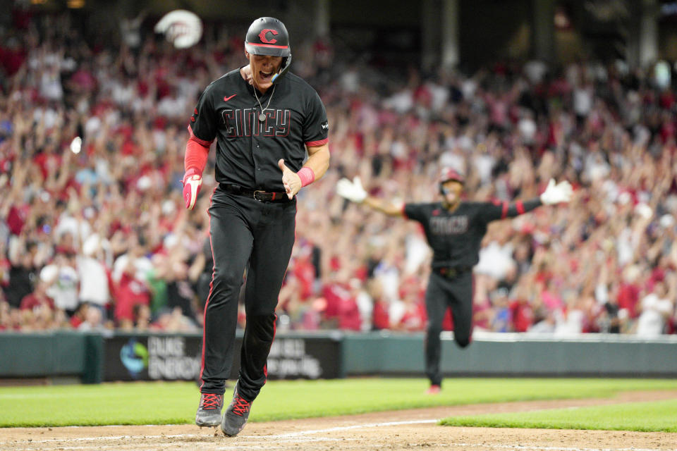 Cincinnati Reds' Tyler Stephenson, left, and Will Benson, back right, react after a Matt McLain grand slam during the fifth inning of a baseball game against the Arizona Diamondbacks, Friday, July 21, 2023, in Cincinnati. (AP Photo/Jeff Dean)