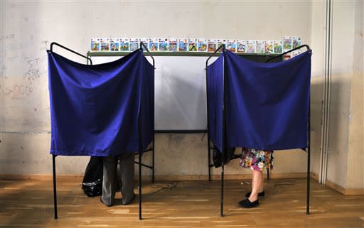 People vote inside booths during the elections in Thessaloniki, Sunday, June 17, 2012. Greeks voted Sunday for the second time in six weeks in what was arguably their country's most critical election in 40 years, with the country's treasured place within the European Union's joint currency in the balance. (AP Photo/Nikolas Giakoumidis)