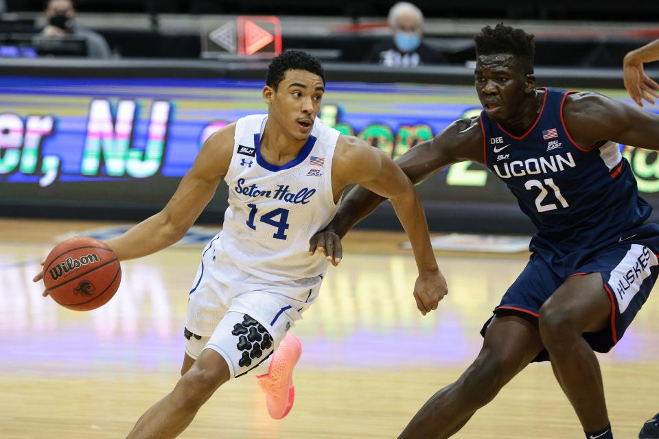 Seton Hall Pirates guard Jared Rhoden (14) dribbles against Connecticut Huskies forward Adama Sanogo (21) at the Prudential Center in 2021.