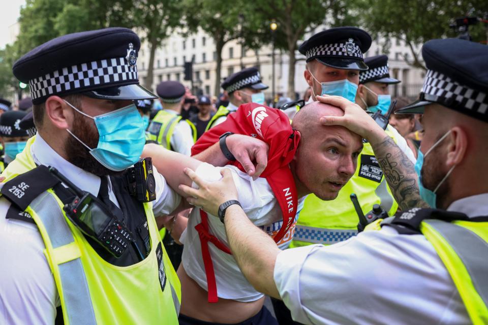 Three London police officers detain a anti-lockdown protestor on a sunny afternoon