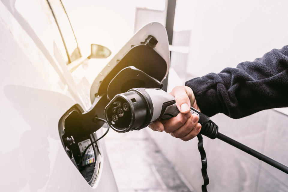 person plugging their electric car in to charge