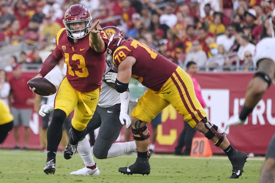 Southern California quarterback Caleb Williams (13) signals as he runs out of the pocket during the first half of the tem's NCAA college football game against Washington State on Saturday, Oct. 8, 2022, in Los Angeles. (AP Photo/Marcio Jose Sanchez)