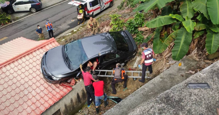 車輛翻落邊坡，卡在民宅屋，車上4人等待救援。（圖／翻攝畫面）