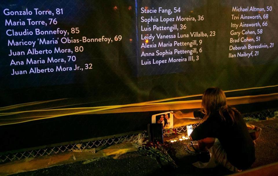 Perla Irala, from Sunny Isles Beach, lit candles near the site of the former Champlain Towers South condo building on Friday, June 24, 2022 in Surfside, Fla. Family members of the 98 victims of the June 24, 2021 condo collapse gathered at the site to mark the one year anniversary of the tragedy.