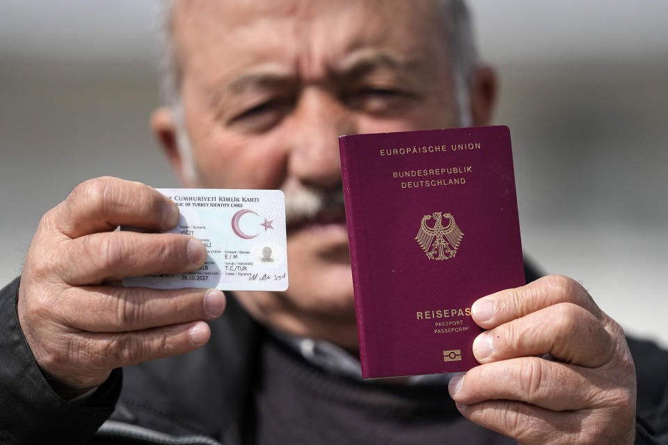 Mehmet Ali Yigit, who has been living in Germany for more than 50 years, shows his German passport and Turkish ID after he voted at the Gruga Hall in Essen, Germany, Thursday, April 27, 2023. Millions of Turkish citizens living abroad have began voting in national elections that will decide whether President Recep Tayyip Erdogan can govern Turkey for another term. Among the biggest contingent of overseas voters are 1.5 million Turks in Germany, who can cast their votes in presidential and parliamentary elections at 16 polling sites across the country until May 9. (AP Photo/Martin Meissner)