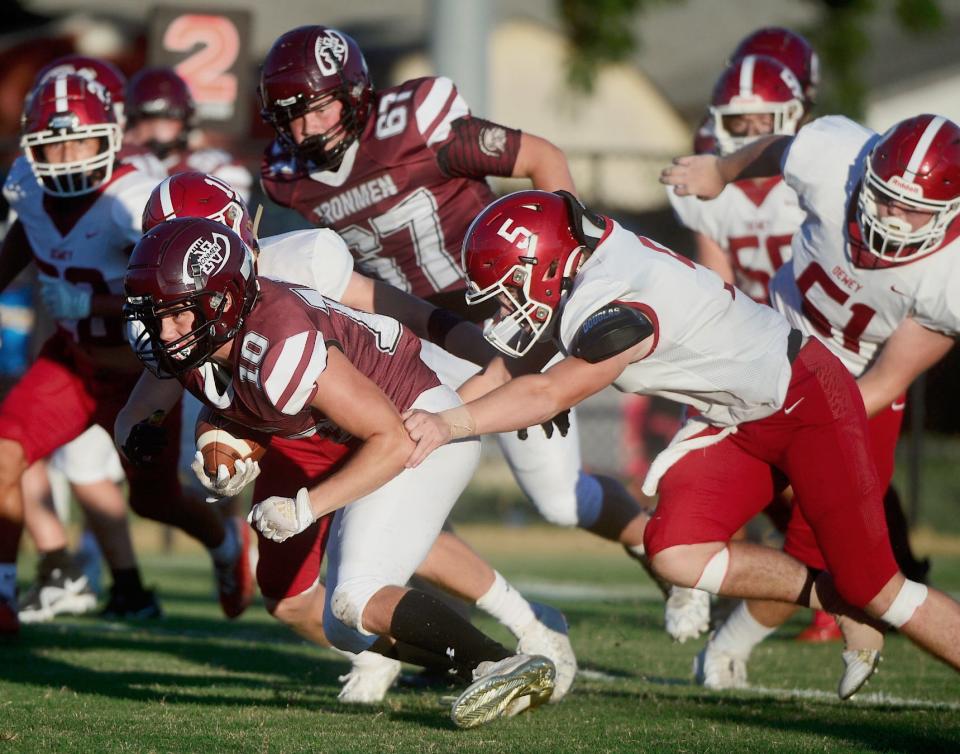 Nowata High's Peyton Trotter, No. 10, powers forward while trying to escape the grip of Dewey's Logan Alspach, No. 5, during varsity football action in 2022in Nowata.