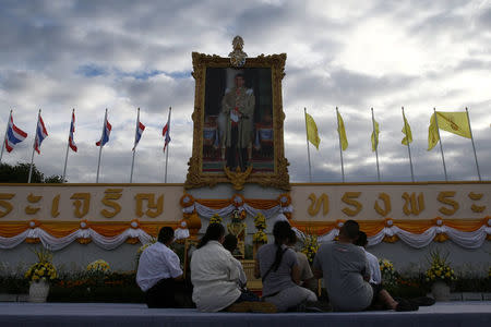 Well-wishers pray in front of a portrait of Thai King Maha Vajiralongkorn as part of celebrations for his 65th birthday in Bangkok, Thailand, July 28, 2017. REUTERS/Athit Perawongmetha