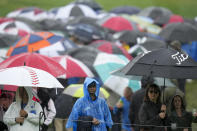 Fans watch in the rain on the ninth hole during the third round of the PGA Championship golf tournament at Oak Hill Country Club on Saturday, May 20, 2023, in Pittsford, N.Y. (AP Photo/Seth Wenig)