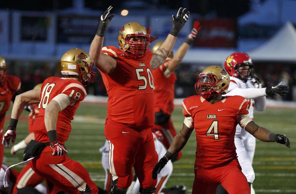 Laval Rouge et Or Pascal Lochard (R) celebrates his touchdown against the Calgary Dinos with teammates Felix Lechasseur (L) and Danny Groulx (C) during the Vanier Cup University Championship football game in Quebec City, Quebec, November 23, 2013. REUTERS/Mathieu Belanger (CANADA - Tags: SPORT FOOTBALL)